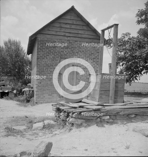 Well and old plantation smokehouse, Chesnee, South Carolina, 1937. Creator: Dorothea Lange.