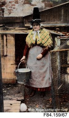 Welsh woman looking after Piggy Welsh costume postcard - woman carrying bucket, c1900s. Creator: Unknown