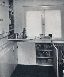 Werner Harting - Kitchen with a black Dutch tiled floor, white walls and built-in shelves and cupbo
