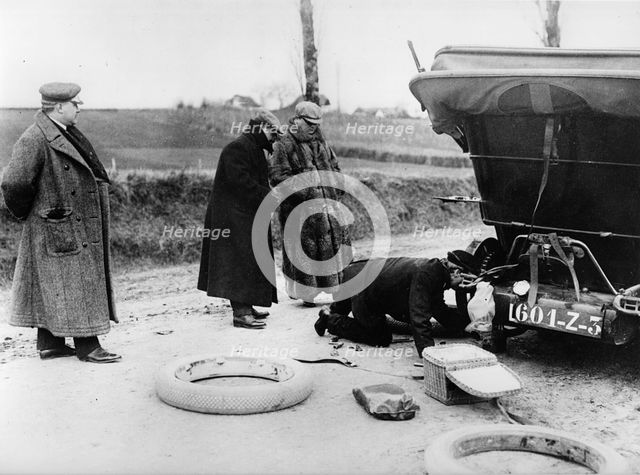 Wheel change by chauffeur on Lord Northcliffe's 1908 Mercedes. Creator: Unknown.