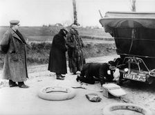 Wheel change by chauffeur on Lord Northcliffe's 1908 Mercedes. Creator: Unknown