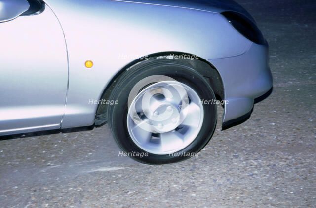 Wheel spin on 1998 Ford Puma producing smoke. Artist: Unknown.