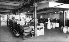 Where machinery is paramount: filling and weighing packages of lard, 1909. Creator: Unknown