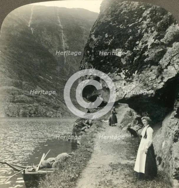 'Where the road creeps under the jutting cliffs by the waters of the Nerofjord, Norway', c1905. Creator: Unknown.