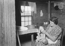Wife of tobacco sharecropper bathing her baby..., Person County, North Carolina, 1939. Creator: Dorothea Lange