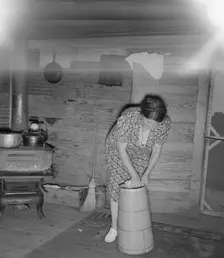 Wife of tobacco sharecropper cleaning butter churn, Person County, North Carolina, 1939. Creator: Dorothea Lange