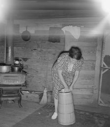 Wife of tobacco sharecropper cleaning butter churn, Person County, North Carolina, 1939. Creator: Dorothea Lange