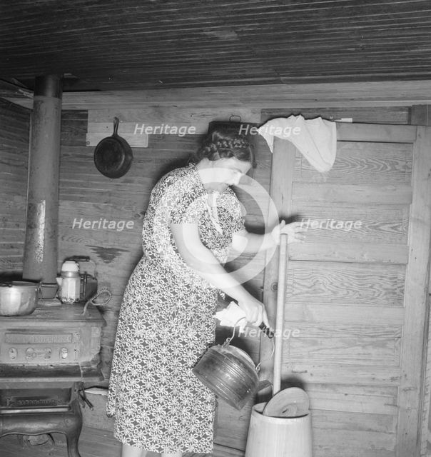 Wife of tobacco sharecropper cleaning butter churn, Person County, North Carolina, 1939. Creator: Dorothea Lange.