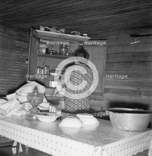 Wife of tobacco sharecropper putting breakfast dishes away. Person County, North Carolina, 1939. Creator: Dorothea Lange.