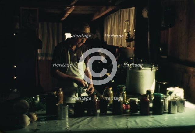 Wife of Jim Norris with canned goods, Pie Town, New Mexico, 1940. Creator: Russell Lee.