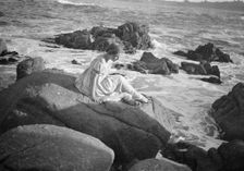 Wilson, Helen, Mrs., seated on rocks at the beach, between 1906 and 1928. Creator: Arnold Genthe