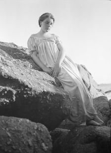 Wilson, Helen, Mrs., seated on rocks at the beach, between 1906 and 1928. Creator: Arnold Genthe