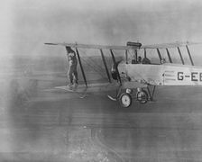Wing walking without a harness on an Avro 504 biplane, 1932. Creator: Aerofilms