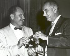 T. Keith Glennan shows Lyndon Johnson aluminized mylar flim used to make the Echo I balloon, 1960.. Creator: NASA