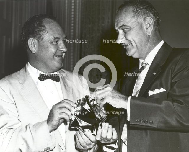 T. Keith Glennan shows Lyndon Johnson aluminized mylar flim used to make the Echo I balloon, 1960.. Creator: NASA.