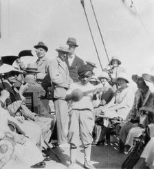 Tourists wathcing a boy playing a ukelele, Havana, Cuba, 1931