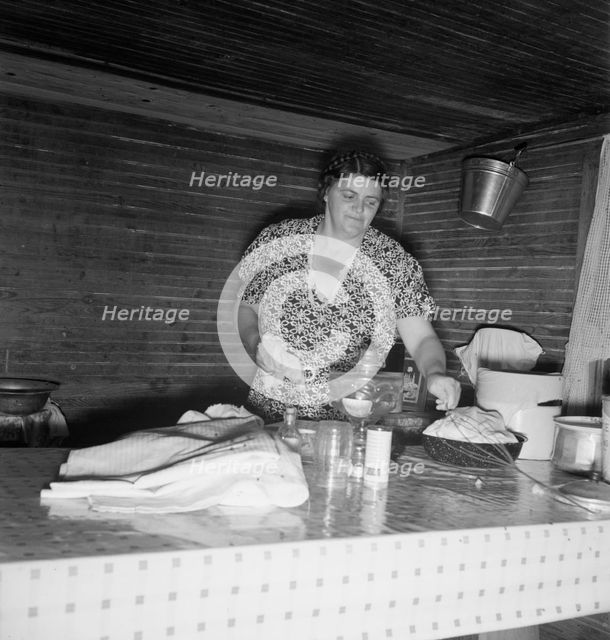 Tobacco sharecropper's wife cleaning up table after washing..., Person County, North Carolina, 1939. Creator: Dorothea Lange.