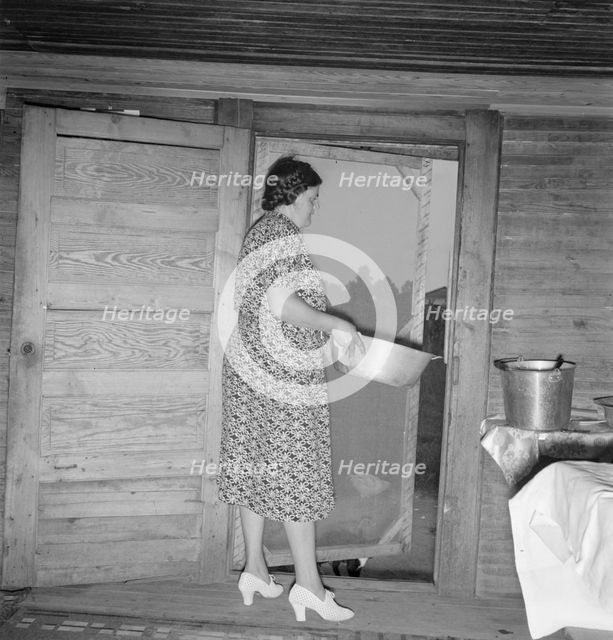 Tobacco sharecropper's wife disposing of dishwater..., Person County, North Carolina, 1939. Creator: Dorothea Lange.