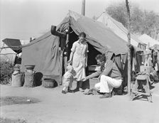 Tom Collins, manager of Kern migrant camp, with drought refugee family, California, 1936. Creator: Dorothea Lange