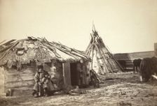 Tatar couple with a small boy in front of their home, between 1885 and 1886. Creator: Unknown