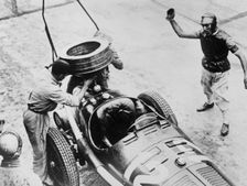 Tazio Nuvolari waiting for his car to be refuelled, c1930s(?)