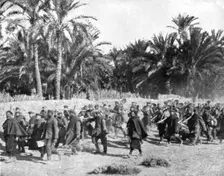 Tandis que.; Voici des prisonniers allemands traversant une riante oasis algerienne pour..., 1917 Creator: Unknown