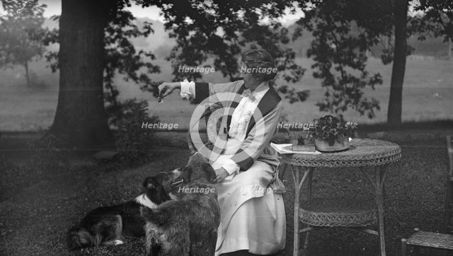 Tarbell, Ida, Miss, with dogs, seated outdoors, 1912 or 1913. Creator: Arnold Genthe.