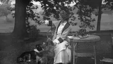 Tarbell, Ida, Miss, with dogs, seated outdoors, 1912 or 1913. Creator: Arnold Genthe