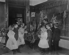 Teacher showing students Native American handicrafts at a school in Washington, D.C., (1899?). Creator: Frances Benjamin Johnston