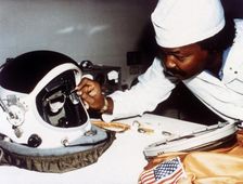 Technician installing eye-glasses in helmet. Creator: NASA
