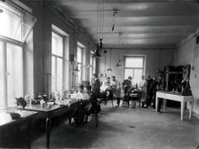 Ten members of staff studying and performing experiments on dogs in the Physiology..., 1904. Creator: Unknown