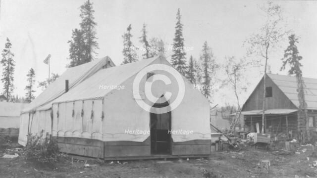 Tent next to log cabin, between c1900 and 1916. Creator: Unknown.