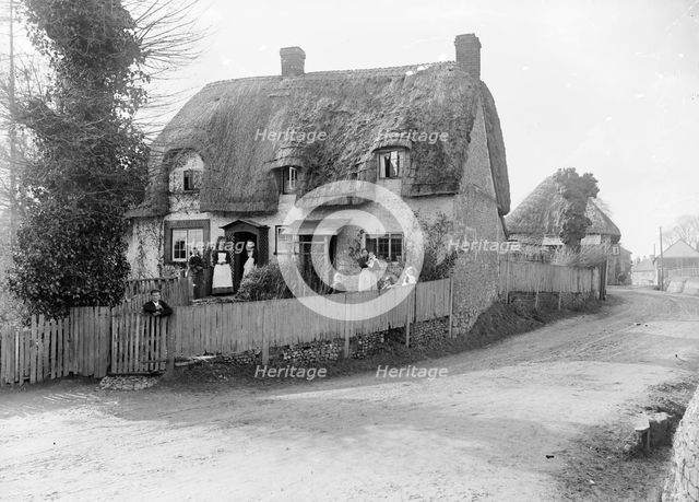 Thatched cottage with its inhabitants standing outside, Ramsbury, Wiltshire, c1860-c1922. Artist: Henry Taunt