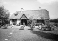 Thatched cottage and garden, c1935. Creator: Kirk & Sons of Cowes