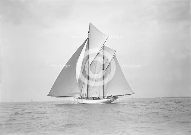 The 118 foot racing yacht 'Cariad' sailing with spinnaker, 1911. Creator: Kirk & Sons of Cowes.
