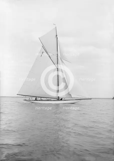 The 12 Metre cutter 'Alachie' sailing in gentle winds, 1913. Creator: Kirk & Sons of Cowes.