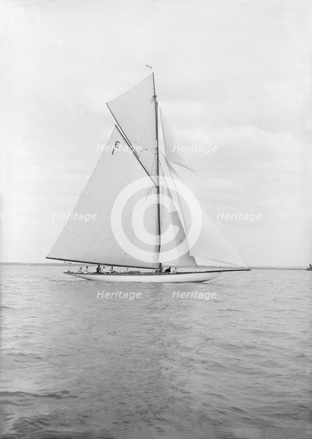 The 12 Metre cutter 'Alachie' sailing in gentle winds, 1913. Creator: Kirk & Sons of Cowes.