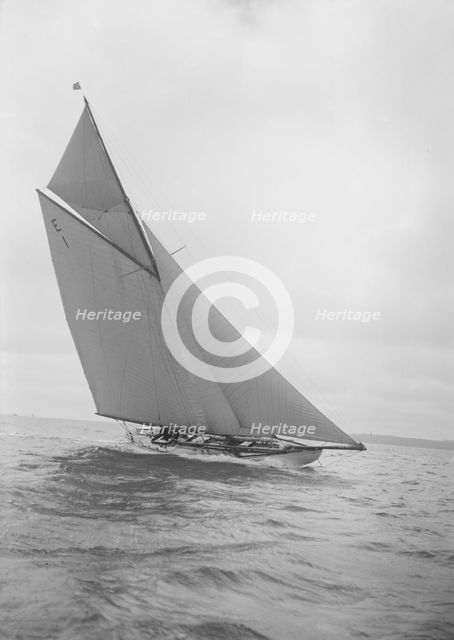 The 12 Metre yacht 'Alachie' makes swift progress upwind, 1911. Creator: Kirk & Sons of Cowes.