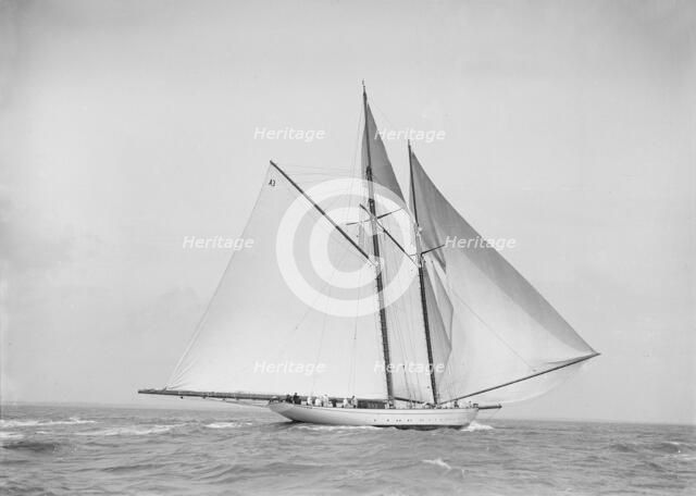 The 250 ton schooner 'Germania' sailing downwind with spinnaker, 1912. Creator: Kirk & Sons of Cowes.