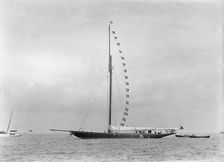 The 221 ton cutter Britannia at anchor with prize flags, 1921. Creator: Kirk & Sons of Cowes