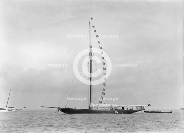 The 221 ton cutter 'Britannia' at anchor with prize flags, 1921. Creator: Kirk & Sons of Cowes.