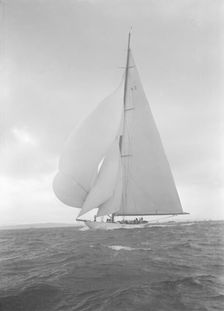 The 23-metre cutter Astra sailing with spinnaker, 1932. Creator: Kirk & Sons of Cowes