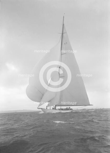 The 23-metre cutter 'Astra' sailing with spinnaker, 1932. Creator: Kirk & Sons of Cowes.