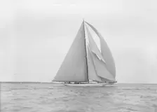 The 23-metre cutter Astra sailing with spinnaker. Creator: Kirk & Sons of Cowes