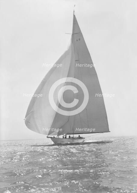 The 23 Metre 'Candida' (K8) sailing with spinnaker, 1935. Creator: Kirk & Sons of Cowes.