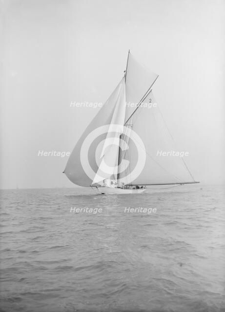 The 40-rater cutter 'Carina' sailing with spinnaker, 1913. Creator: Kirk & Sons of Cowes.