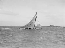 The 7 Metre Ginerva (K7) under sail with prize flags, 1912. Creator: Kirk & Sons of Cowes