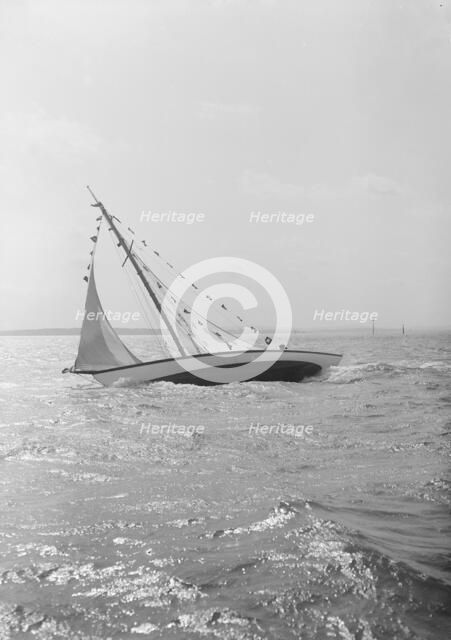 The 7 Metre 'Ginerva' (K7) under sail with prize flags, 1912. Creator: Kirk & Sons of Cowes.