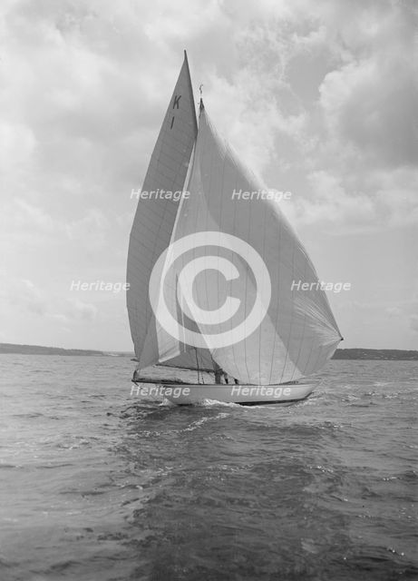 The 7 Metre 'Marsinah' (K1) sailing with spinnaker, 1912. Creator: Kirk & Sons of Cowes.