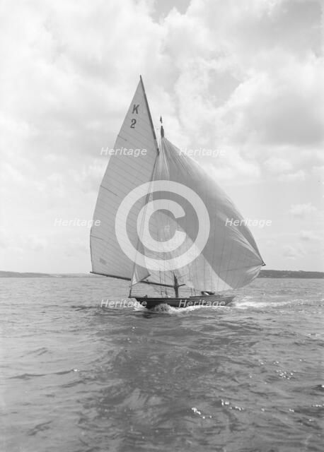 The 7 Metre yacht 'Ithnan' (K2) sailing with spinnaker, 1912. Creator: Kirk & Sons of Cowes.